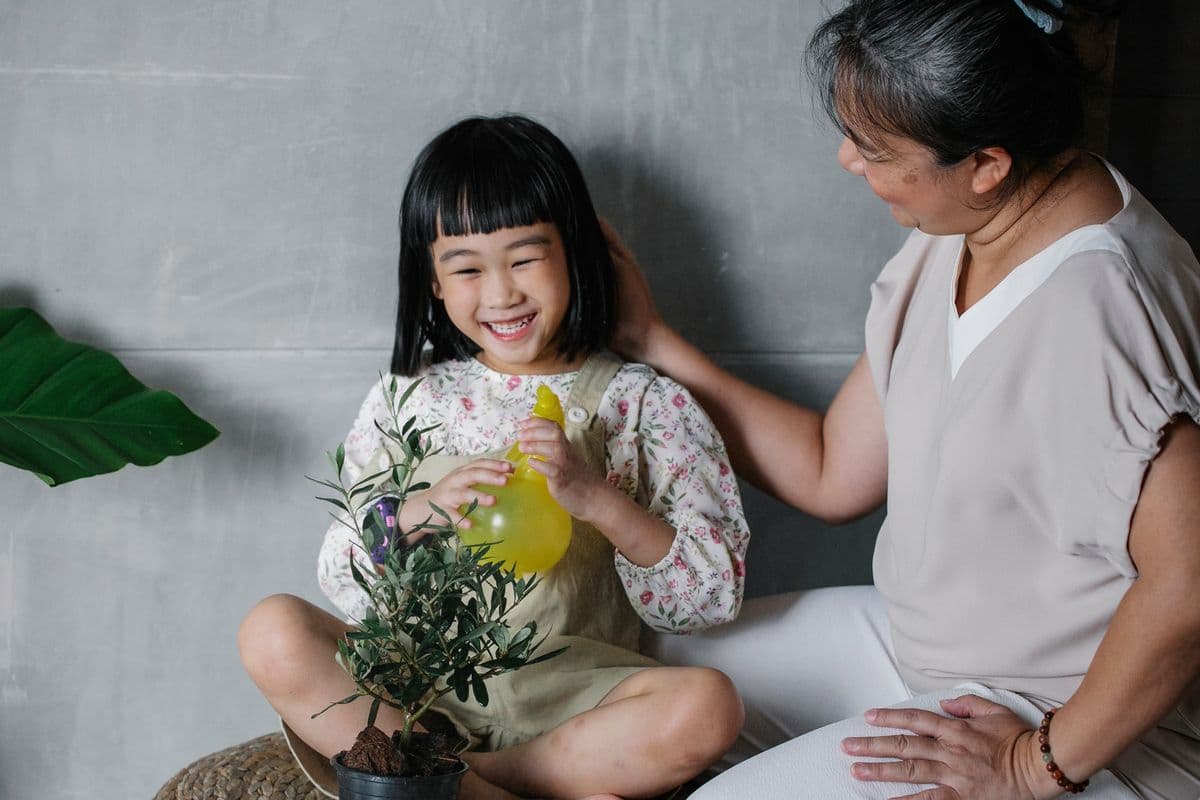 Grootmoeder lacht samen met haar kleindochter bij een plantje